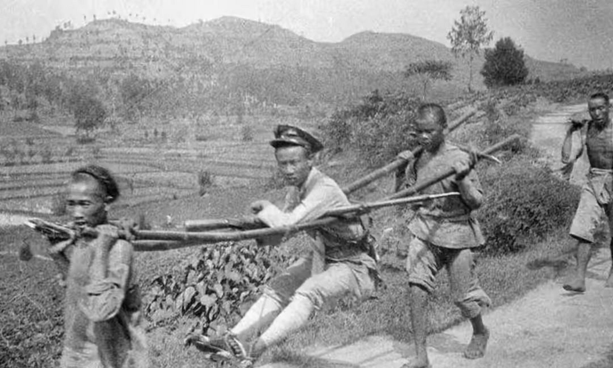 民国老照片.1918年,四川地区,一个士兵坐着滑竿,两个轿夫抬着他.