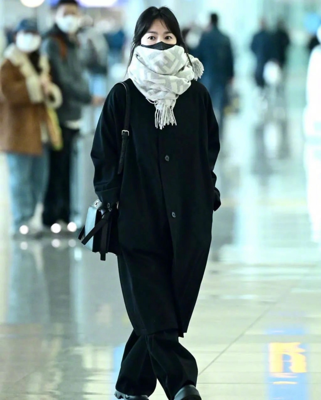宋慧乔机场街拍,前往米兰时装周看秀,一身黑,用fendi浅色围巾做了点缀