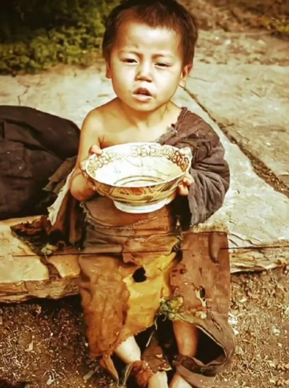 1946年,湖南地区,一个三四岁的小孩穿着破旧的衣服