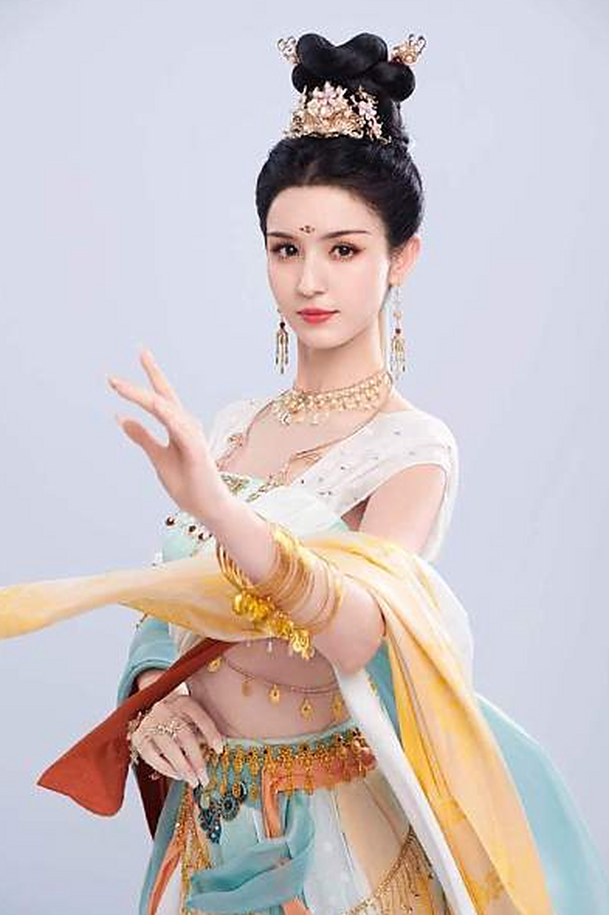 长裙仙气飘飘  哈妮克孜身穿一袭白色长裙,头戴金色发饰,手持飞天翅膀