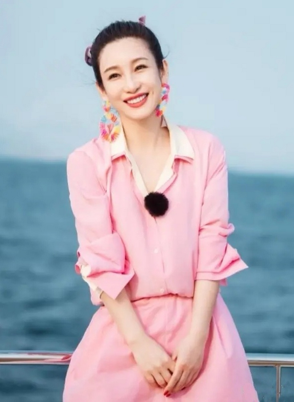 秦海璐,身穿粉色连体裤,发型是把粉色印花发带编进