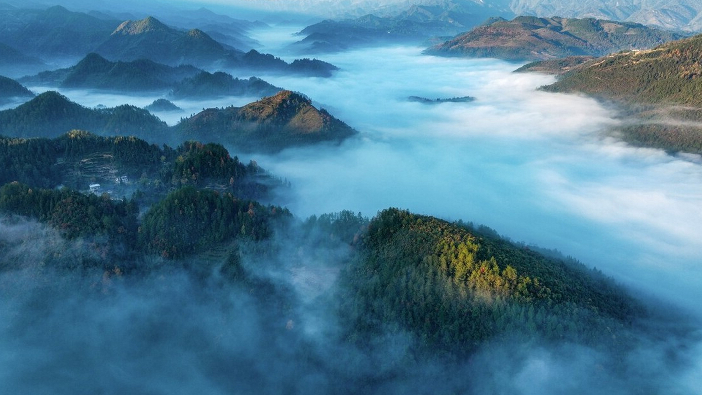 初冬的清晨,重庆酉阳红鱼溪云雾弥漫,雾气缠绕着山峦,五彩斑斓的群山