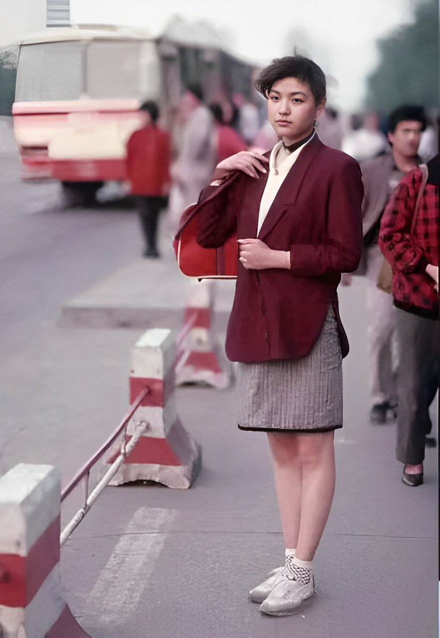 这是90年代,一位打扮时尚的年轻女孩在街边的留影.