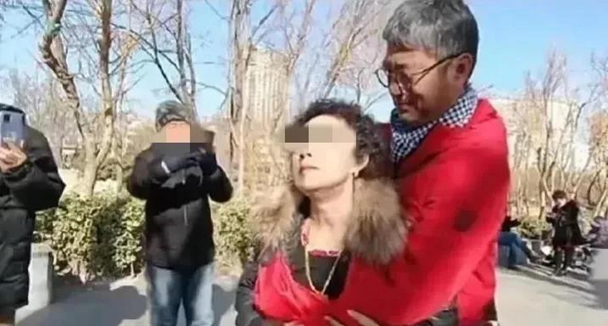 公园里,一对大爷大妈不顾路人侧目,正在忘情的跳着广场舞,不少围观