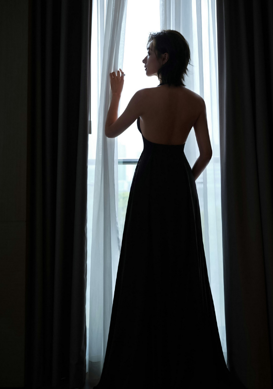 万茜露背长裙# 万茜品质盛典礼服是黑色露背长裙,站在窗边的背影好绝