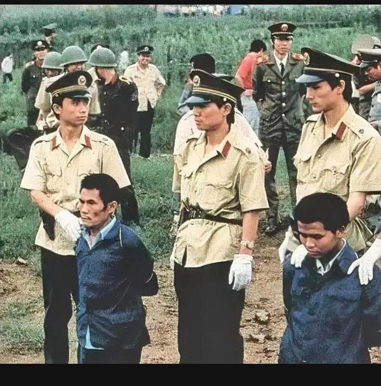 这是90年代,郊外的刑场上,两名犯人被执行死刑的现场,照片中的他们
