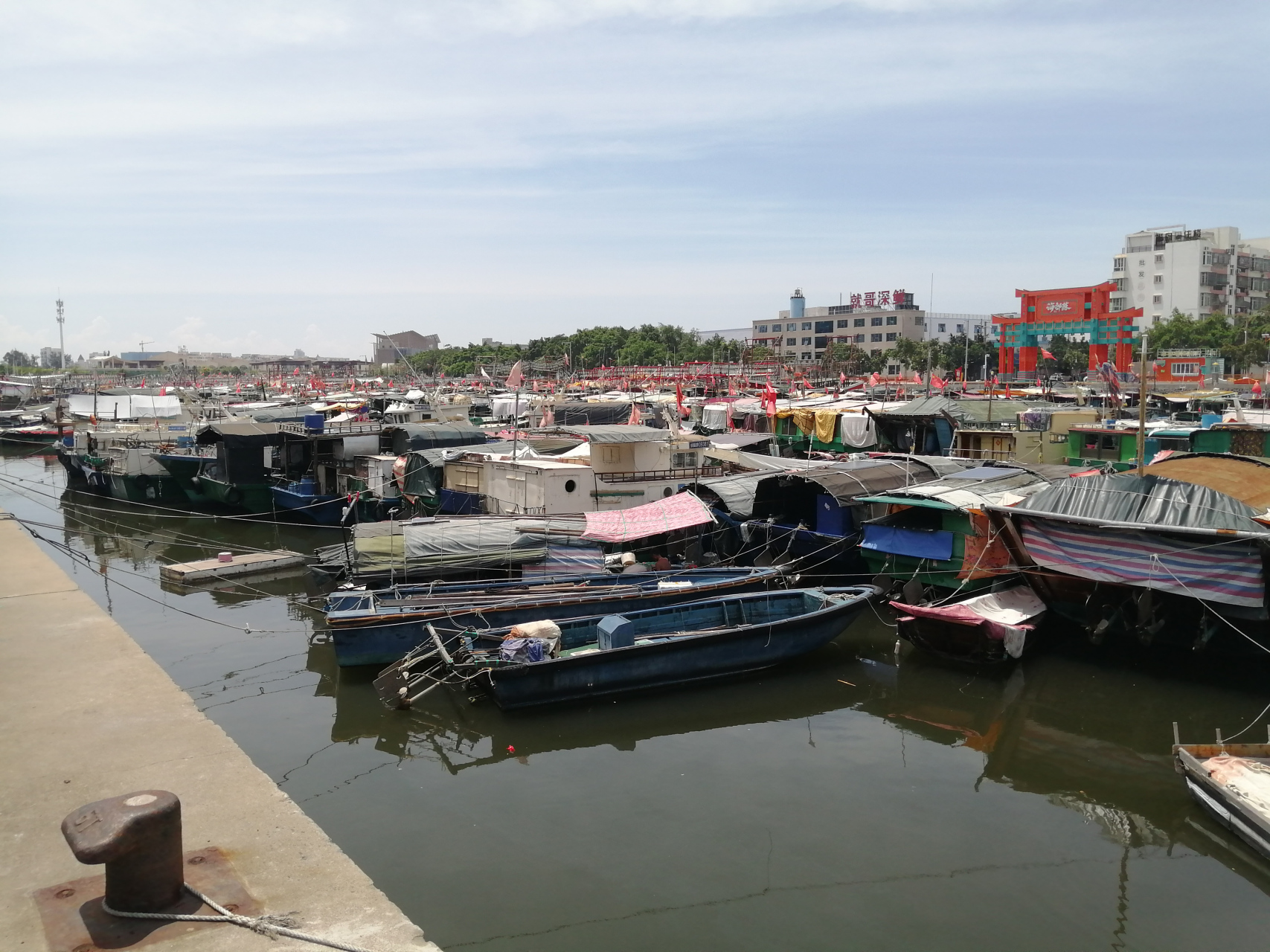 北海市侨港镇的内港停了很多渔船,望不到头,旁边的马路对面是一排大
