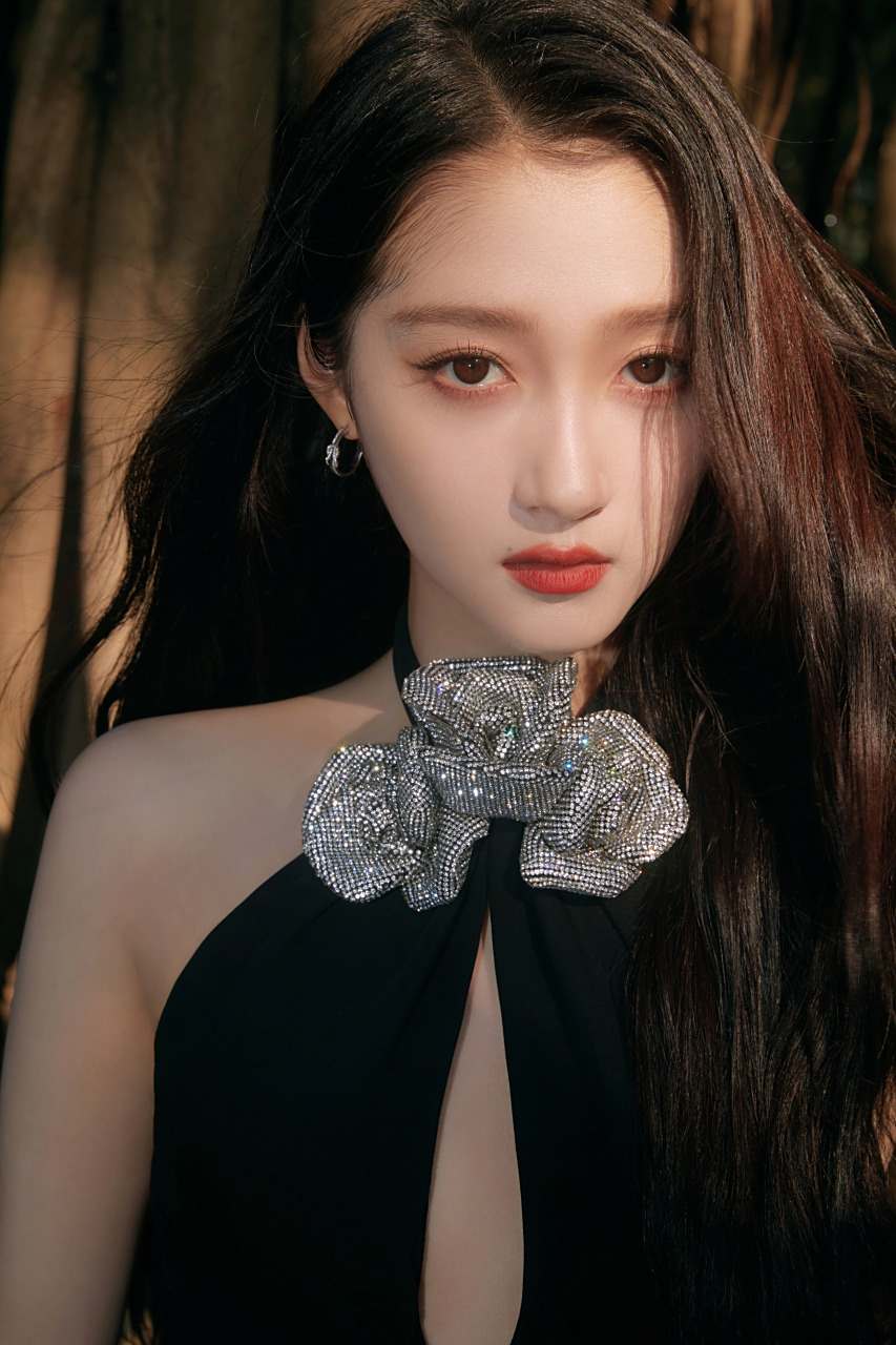 关晓彤挂脖玫瑰黑裙,穿梭在光影与树木间.