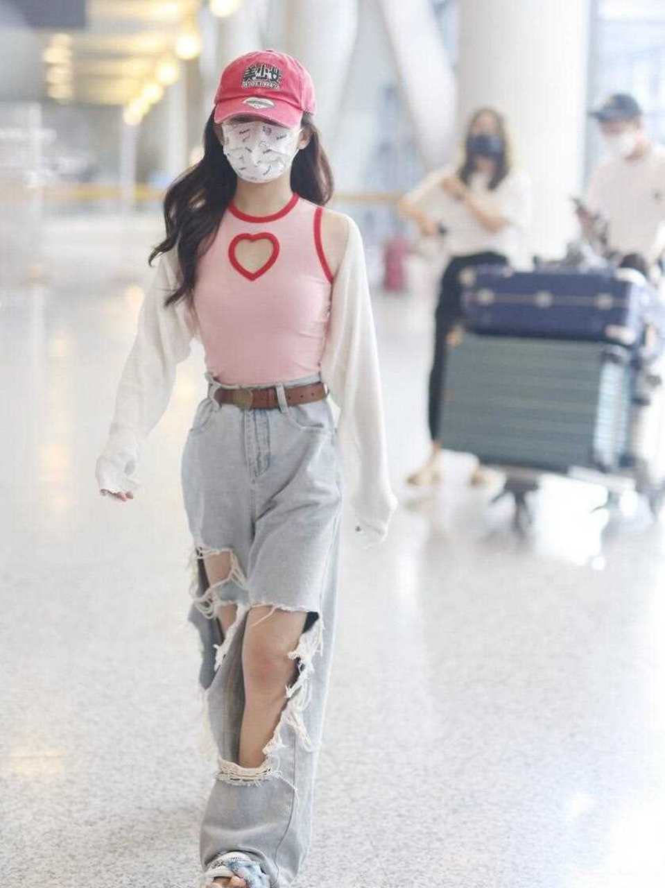 时髦女孩赖美云最新机场照来了,她戴一顶红色棒球帽,穿一件白色短款