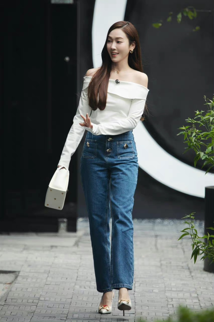 郑秀妍(jessica jung)身穿白色一字肩上衣搭配蓝色牛仔裤和一双高跟鞋