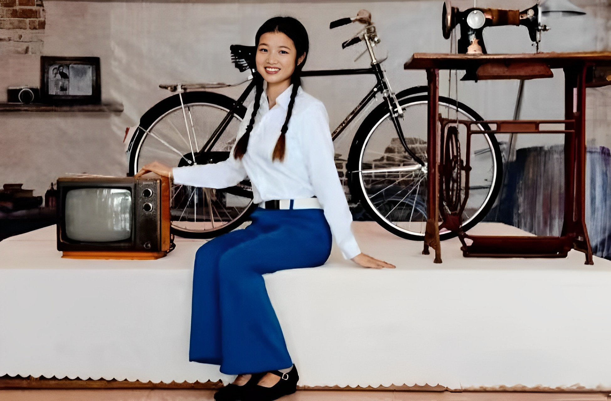 这是一位漂亮女孩和八零年代陪嫁三件套的合影.