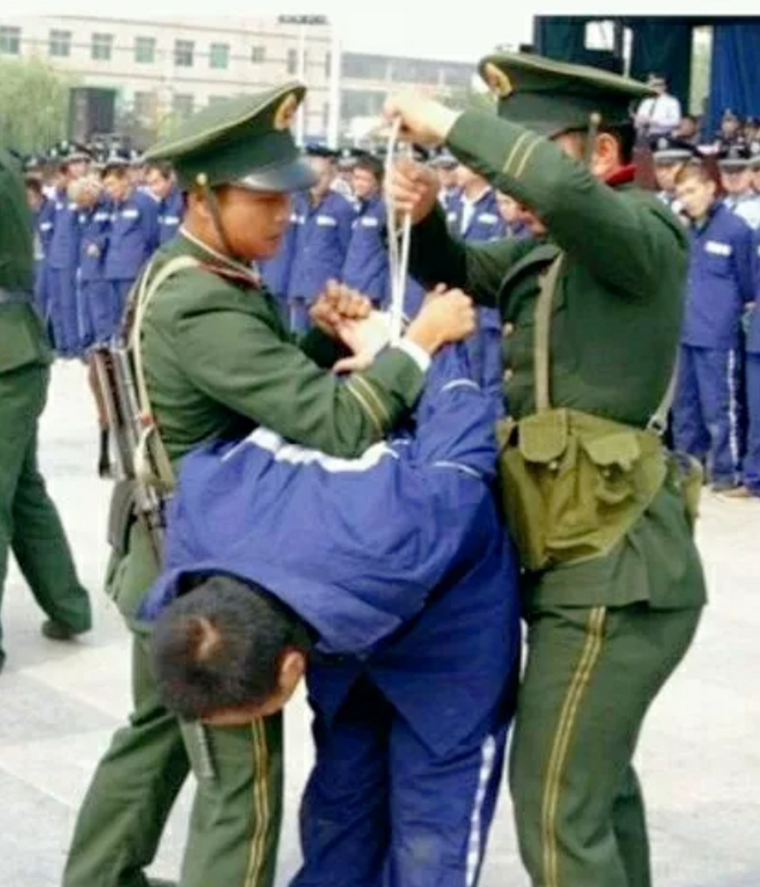 老照片,90年代,公审大会现场,一名犯人被宣判死刑后,两名武警战士为他