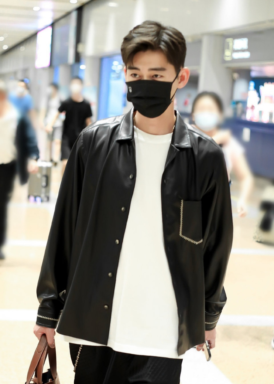 张翰出现在机场,他上身穿黑色皮衬衣,下身搭配皮质格纹裤,很有型男范