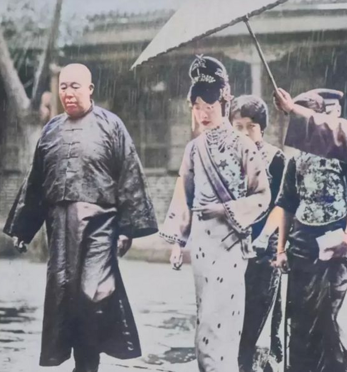 1934年,婉容在太监陪同下冒雨行走的照片,当时身形消瘦面色惨淡 1934