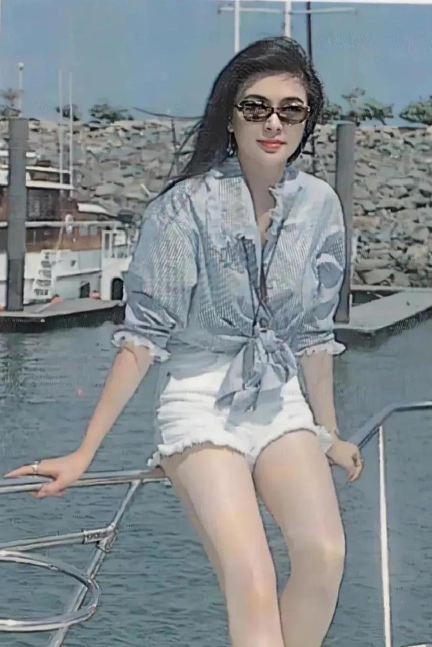 上世纪90年代,在海边度假的关之琳站在游艇的护栏上拍了一张照片.