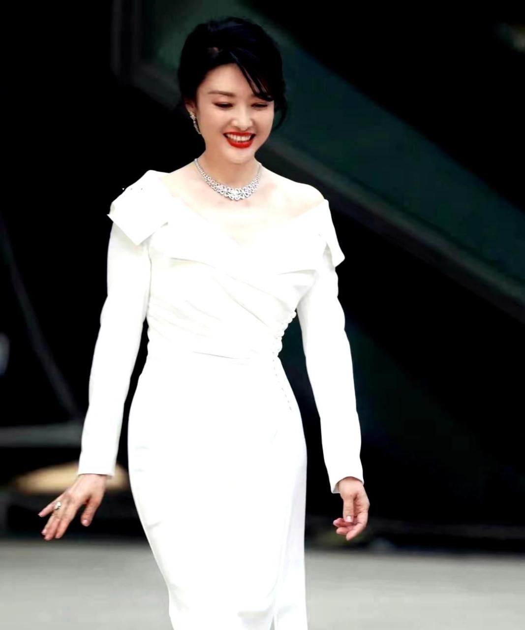 周涛55岁时出席活动,身穿一件白色褶皱开叉长裙,展现出温柔优雅的气质