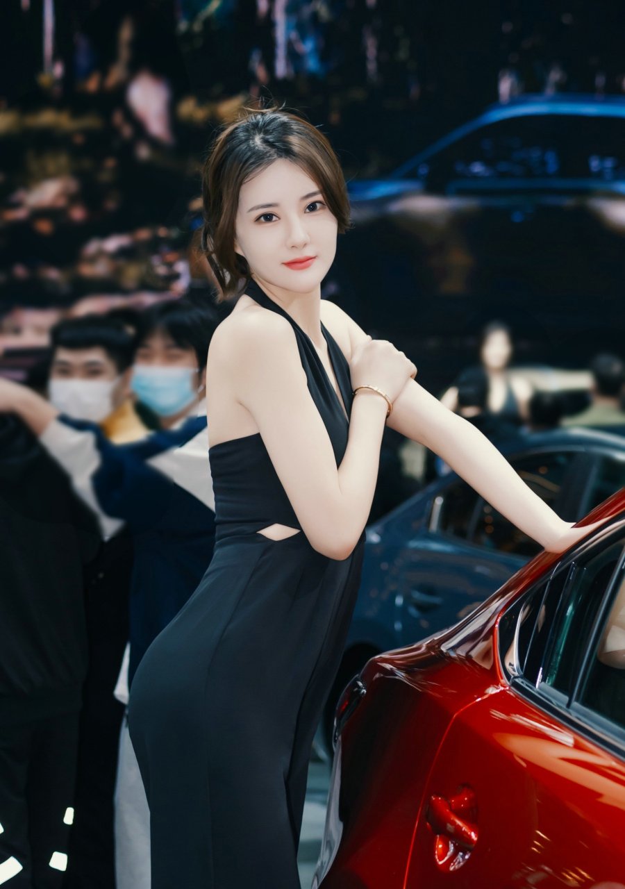 在车展上,那位漂亮的车模吸引了众人的目光.