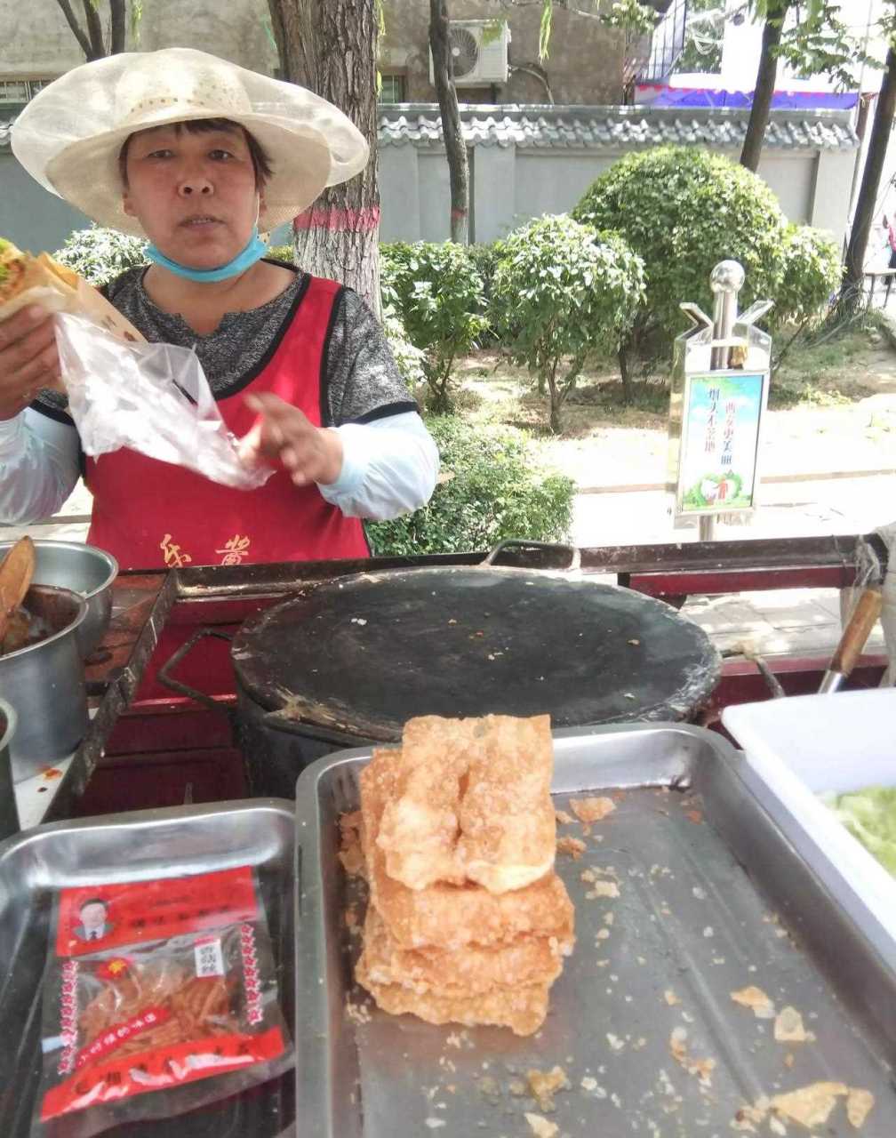 在灞桥东郊车管所,看见一个卖杂粮煎饼的大嫂,手脚麻利,生意红火,做的