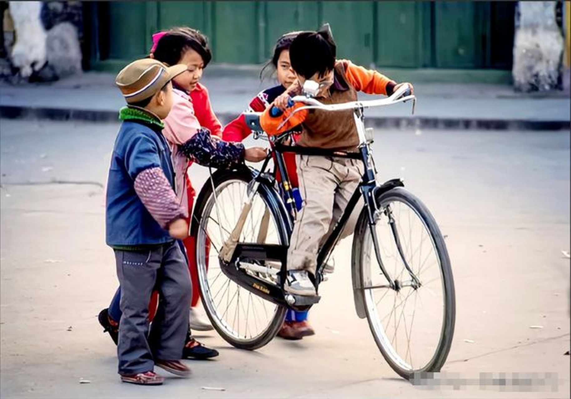 广西阳朔街头,一个孩童骑着一辆二八大杠自行车,景象惹人怀念.