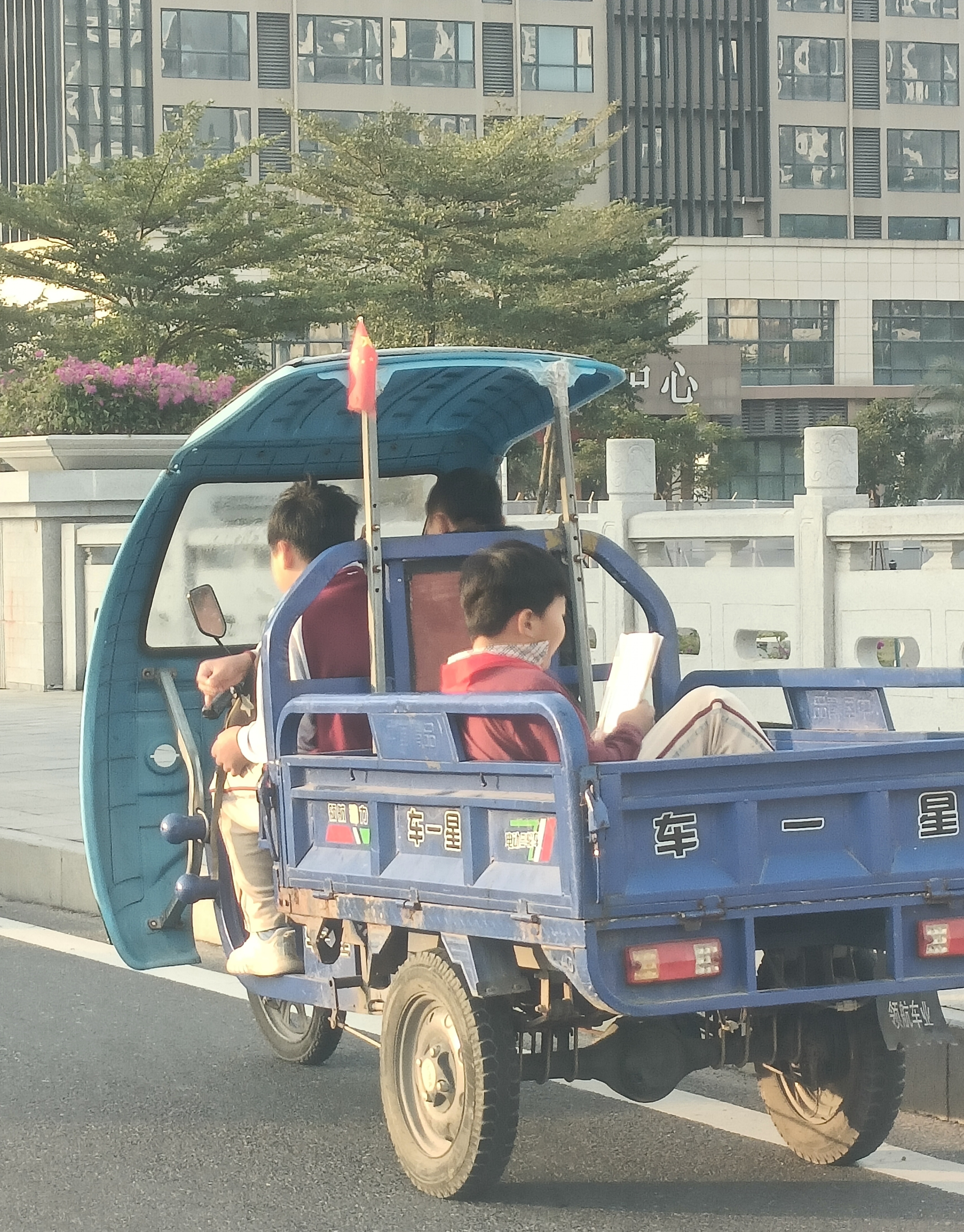 早上上班的路上,看到一个坐在三轮车尾箱的小学生在拿着书本大声的读