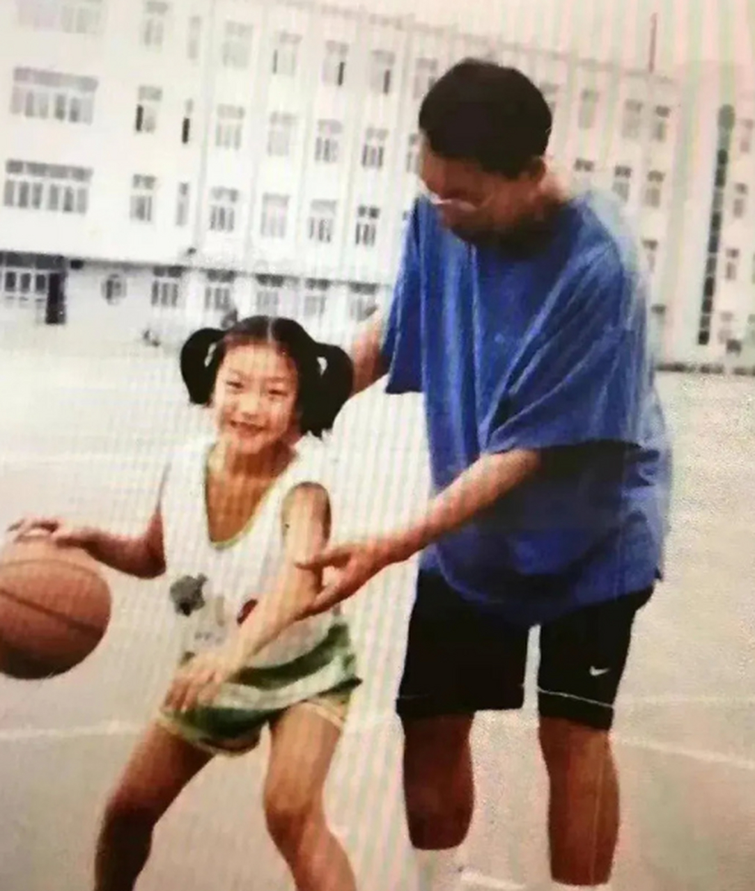 这是女篮李梦小时候的照片,当时她正与爸爸一起练球.