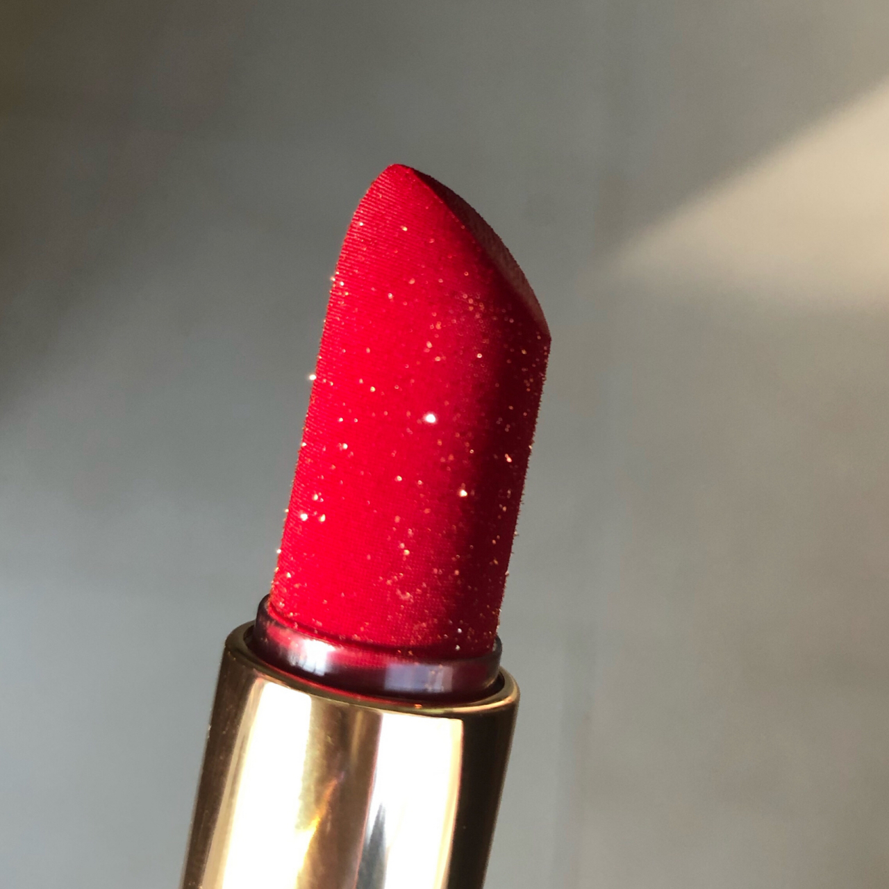 苹果红颜色的口红. 膏体上面是亮晶晶的细闪,上嘴特别好看.