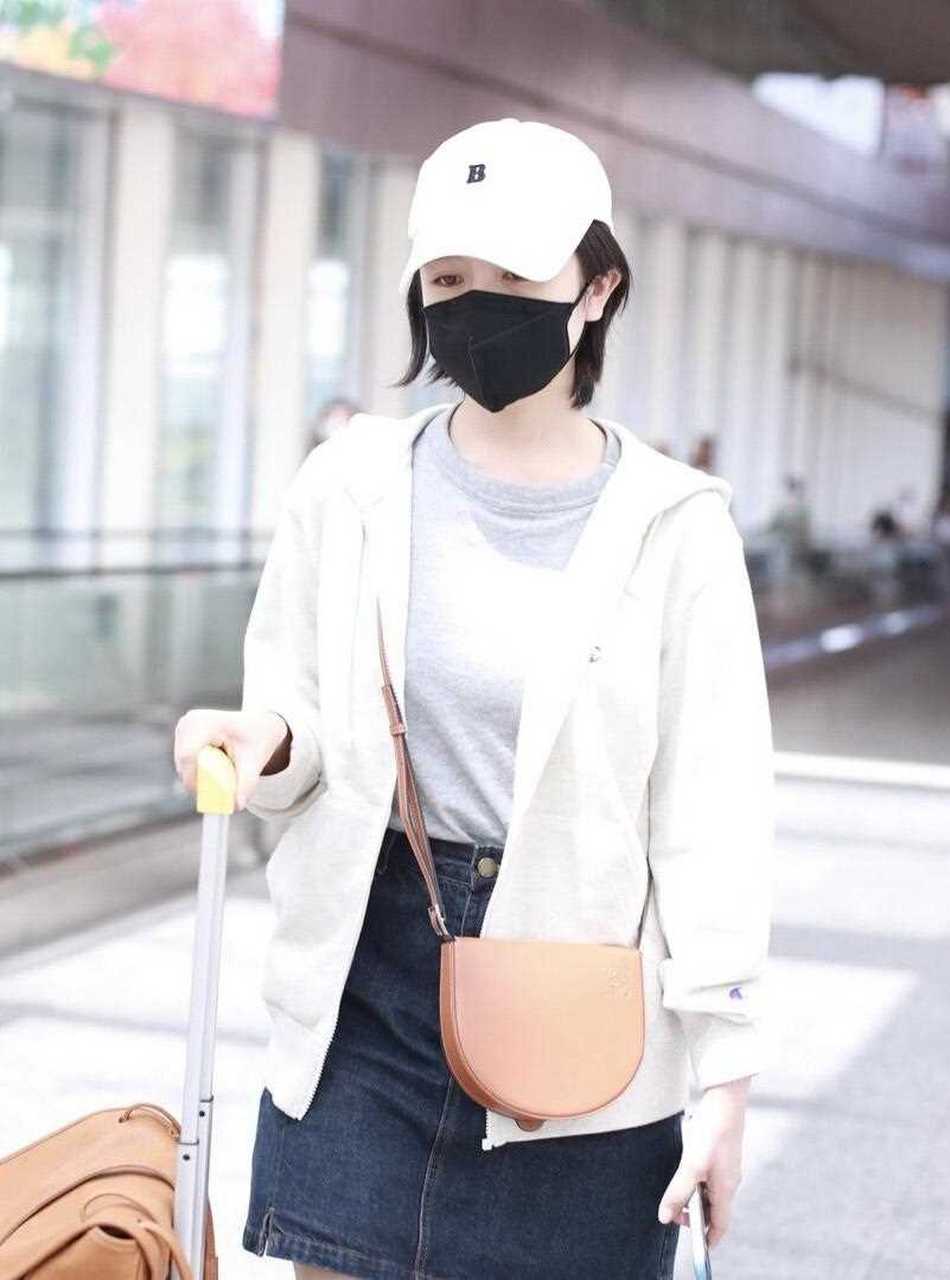 小美女李兰迪最新机场照,她戴了一顶白色的棒球帽,穿一件白色衬衫,内