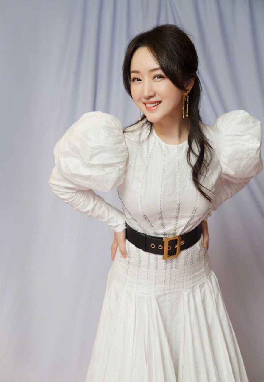 49岁的杨钰莹照片:她出席某商演时身穿白色长裙,搭配着卷发,依然走