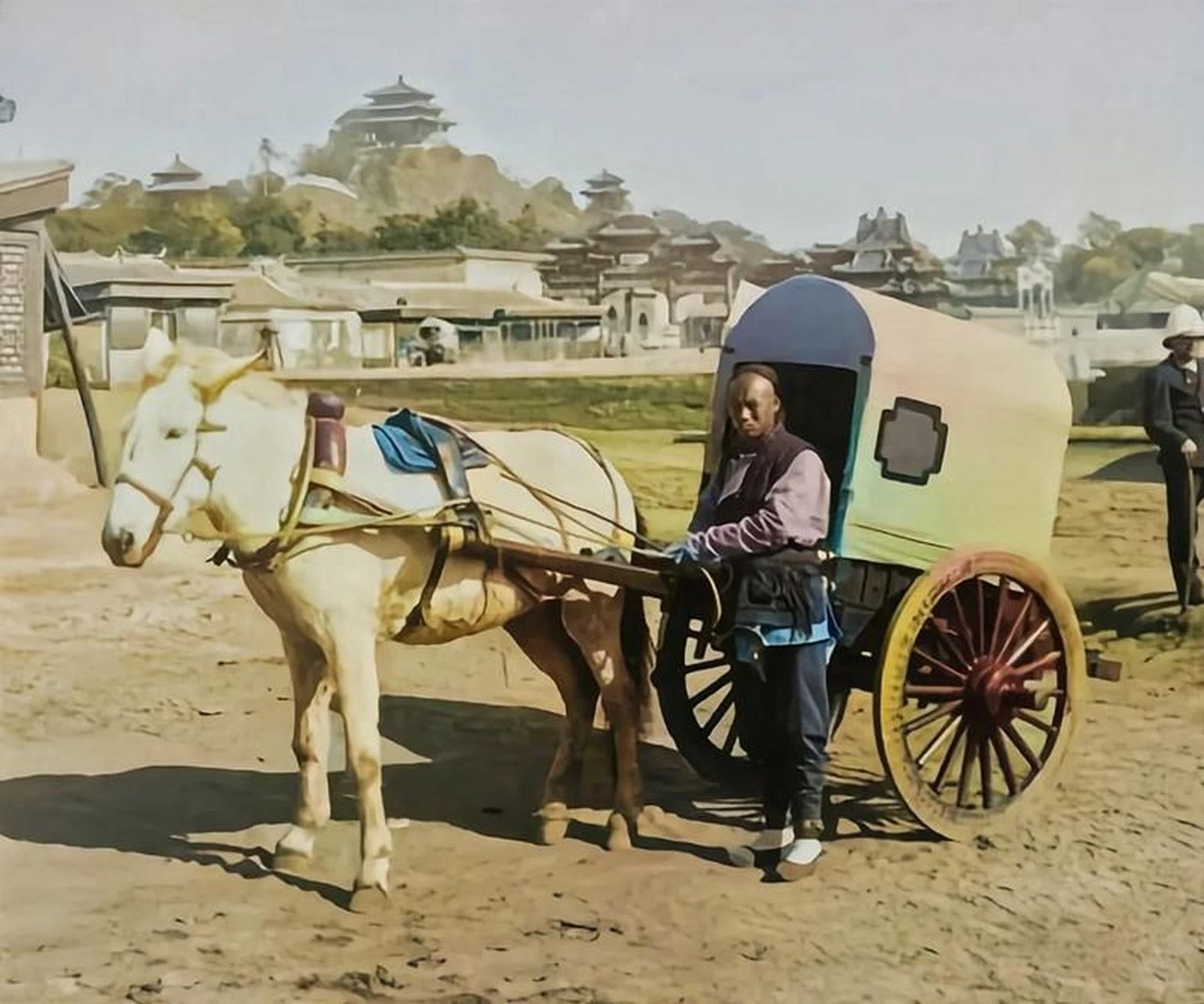 車伕與馬車合影.照片中,一個車伕牽著一個白馬馬車.