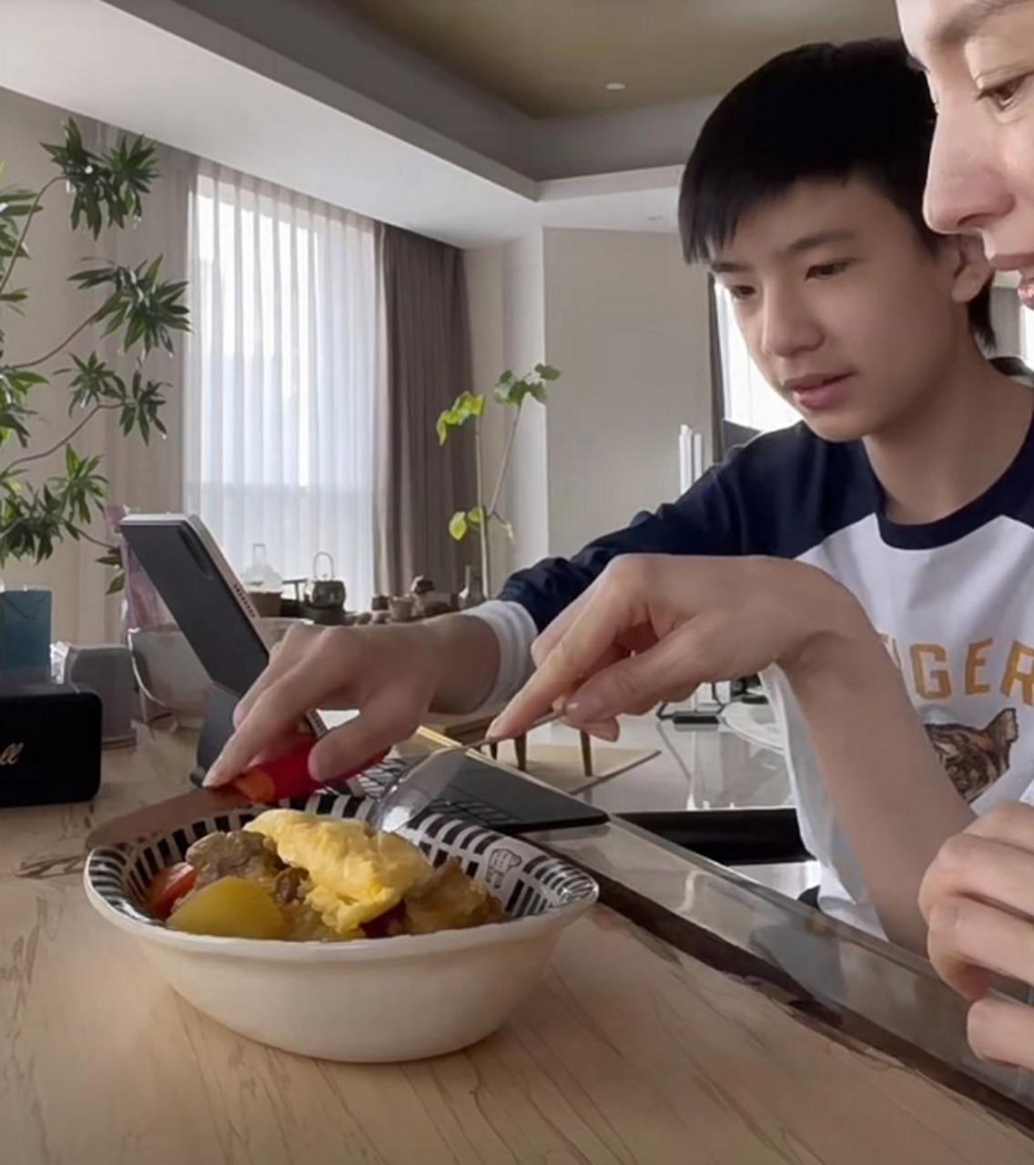 潘粤明儿子顶顶在家玩平板,董洁为孩子做蛋包饭,脸很小但五官比较端正