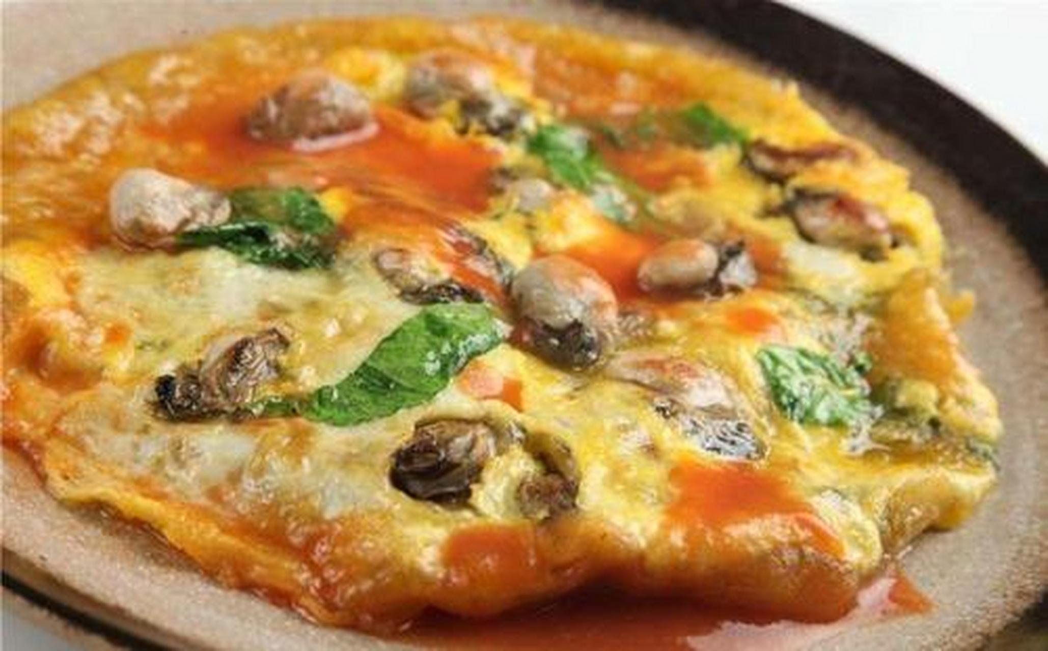 台湾蚵仔煎是一道以鲜蚵,鸡蛋,太白粉,地瓜粉,青菜,香葱及海鲜汁作为