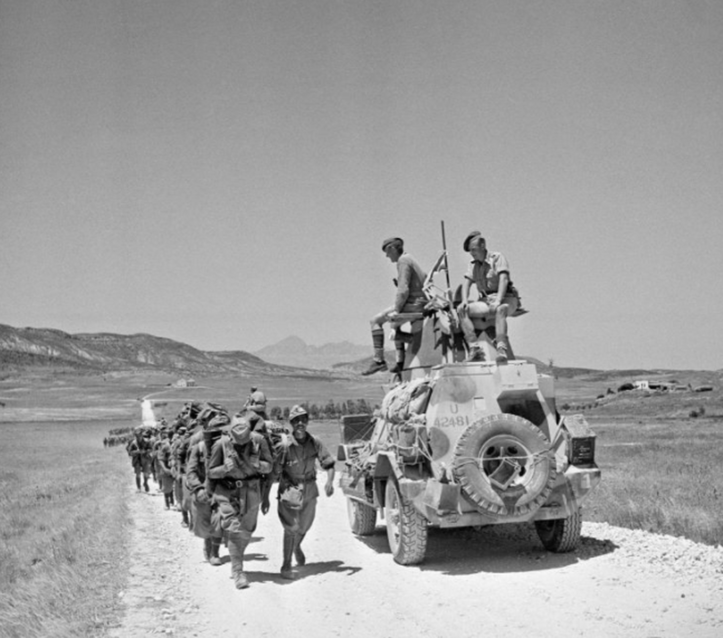 1943年5月20日,一辆英军装甲车经过一队走向战俘营的意大利战俘