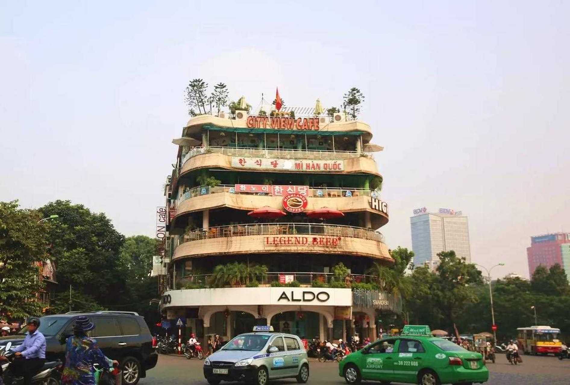 河内老城区绿树成荫的街道,阳光很好,路上的行人走的不紧不慢.