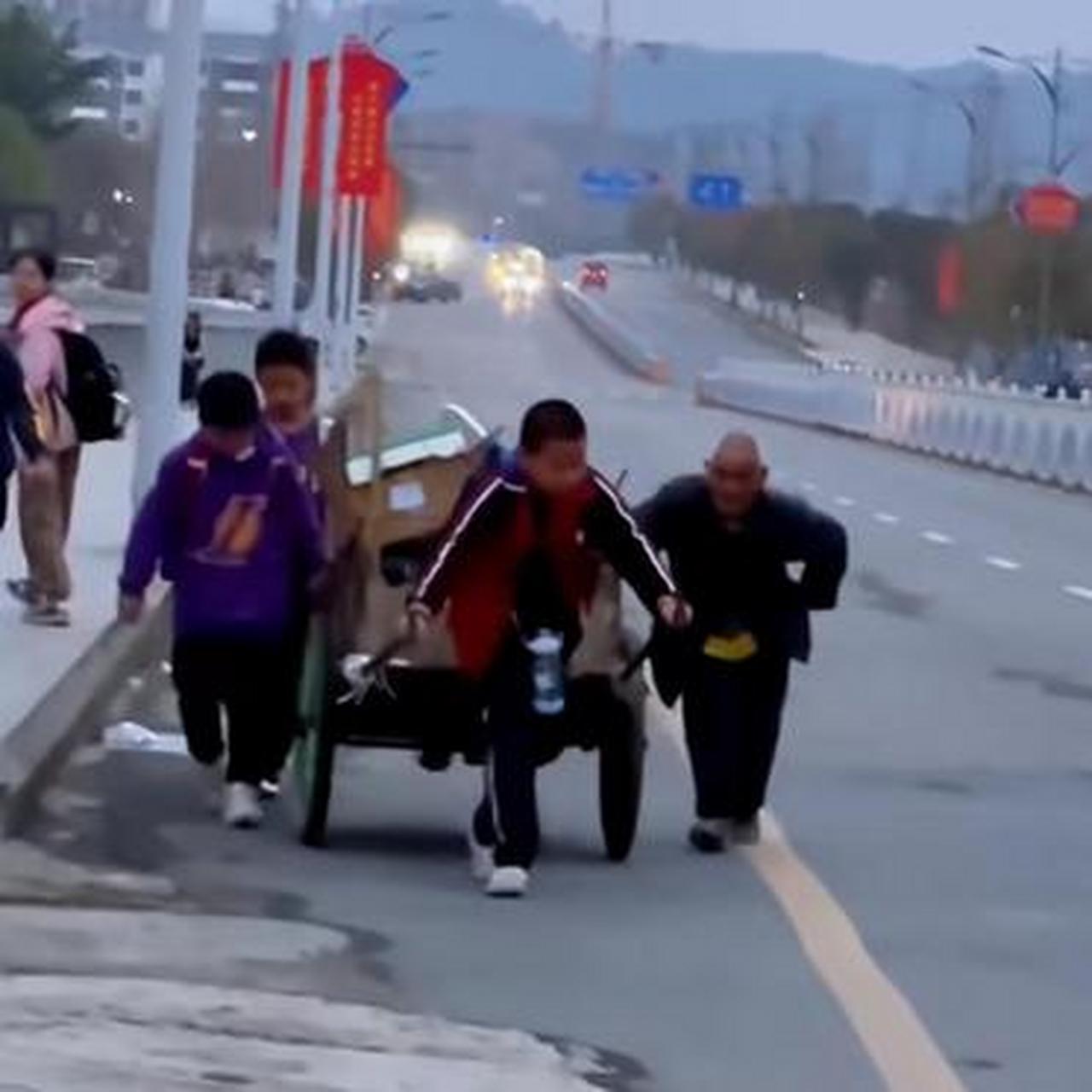 老人拉著收廢品車子艱難上坡,幾名小學生熱心幫老人拉車,點贊