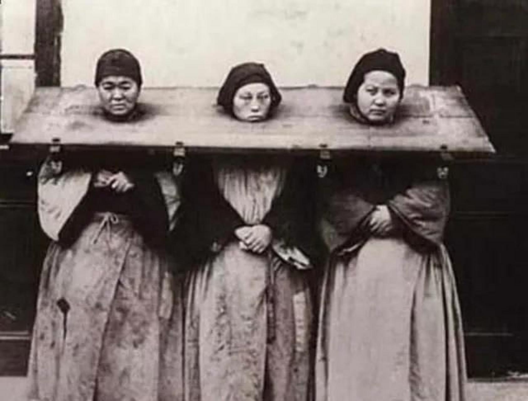 晚清老照片: 一副枷锁,锁着三名女囚犯.