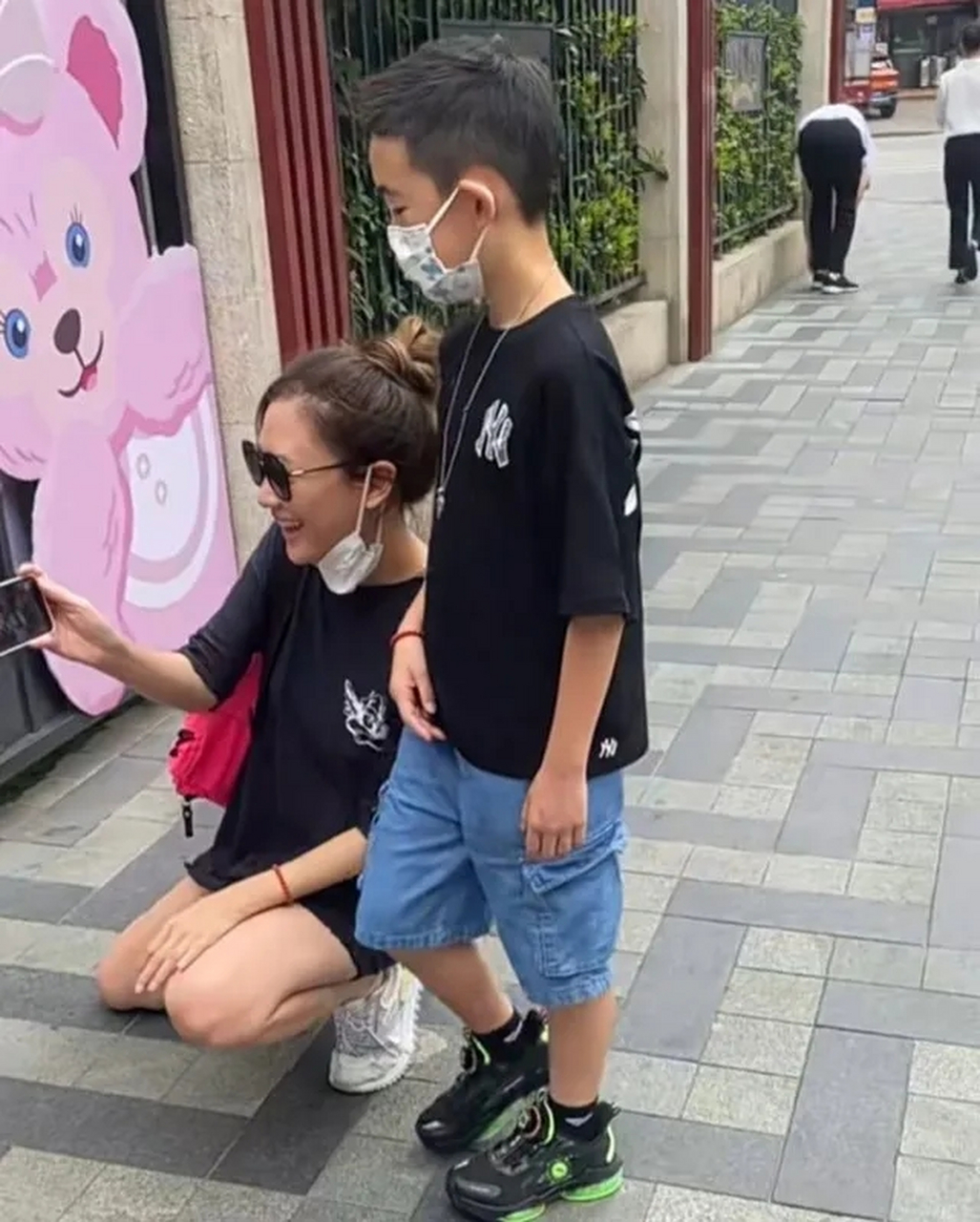 应采儿带着jasper接小儿子hoho放学,2岁的hoho背着小书包,应采儿蹲着