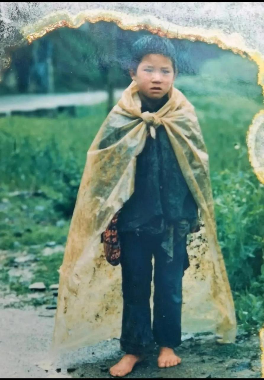 在上世纪90年代的陕西安康,一个农村的小孩子,身上披着一张塑料布