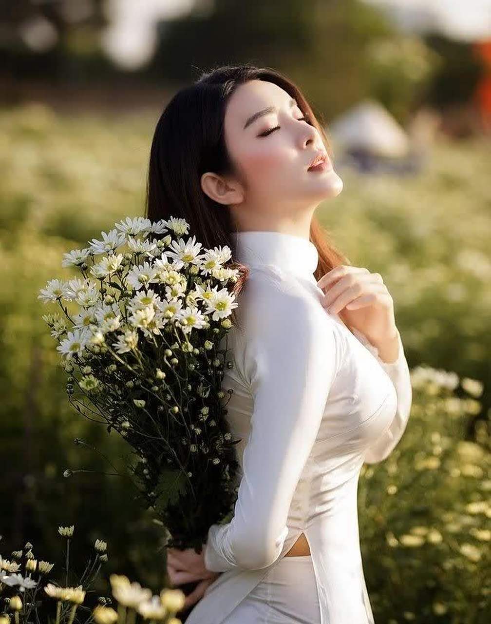 身穿白色奥黛的美人,花丛中展现迷人的气质,傲人的身材特别抢眼