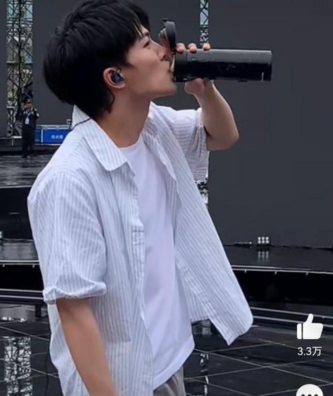 周深穿着短袖短裤,手里拿着电风扇,还一边喝水热?