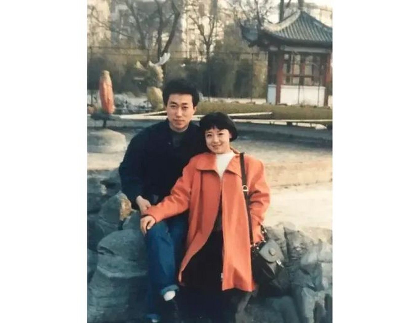 女孩搭手放在男孩的膝盖上,身子斜依在男孩身边,两个人相互依偎