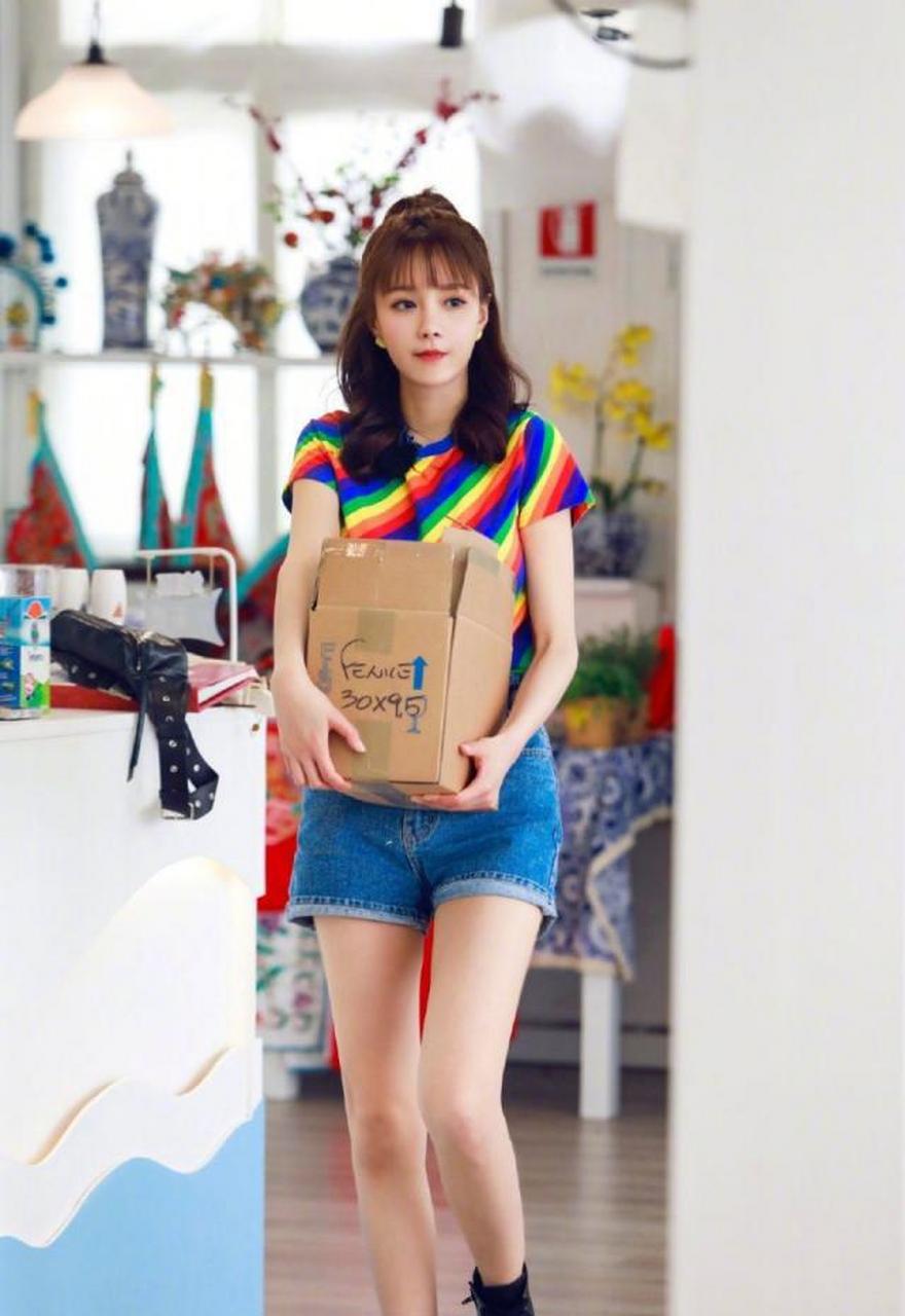 沈梦辰身穿彩虹t恤搭配牛仔短裤,绚丽夺目,这样一身搭配简单又时髦,走