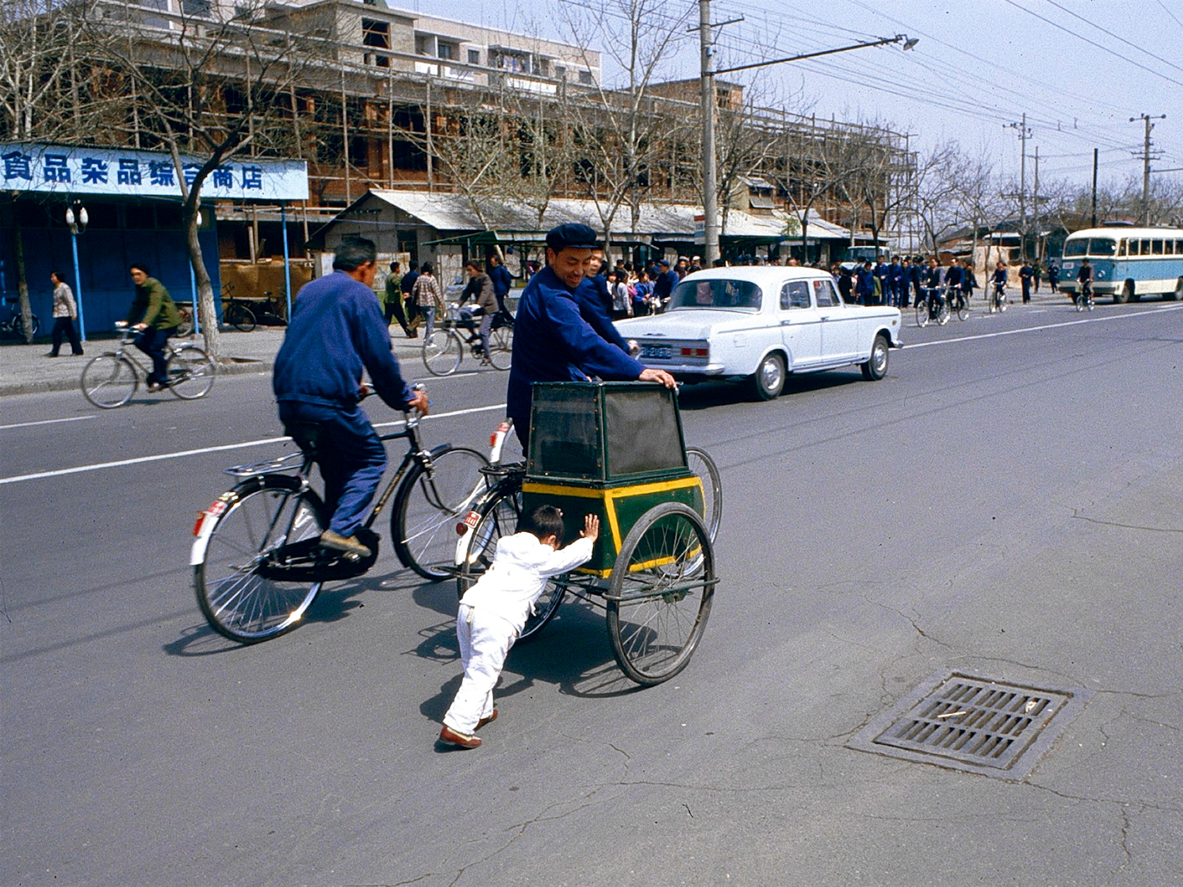 80年代的北京街头,宽广的马路上穿梭的是"二八大杠",只有一辆公交车和