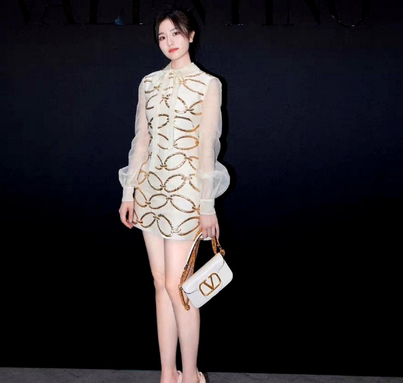 李兰迪难得穿上高跟鞋亮相活动,她身着浅色金丝线礼服十分抢眼.