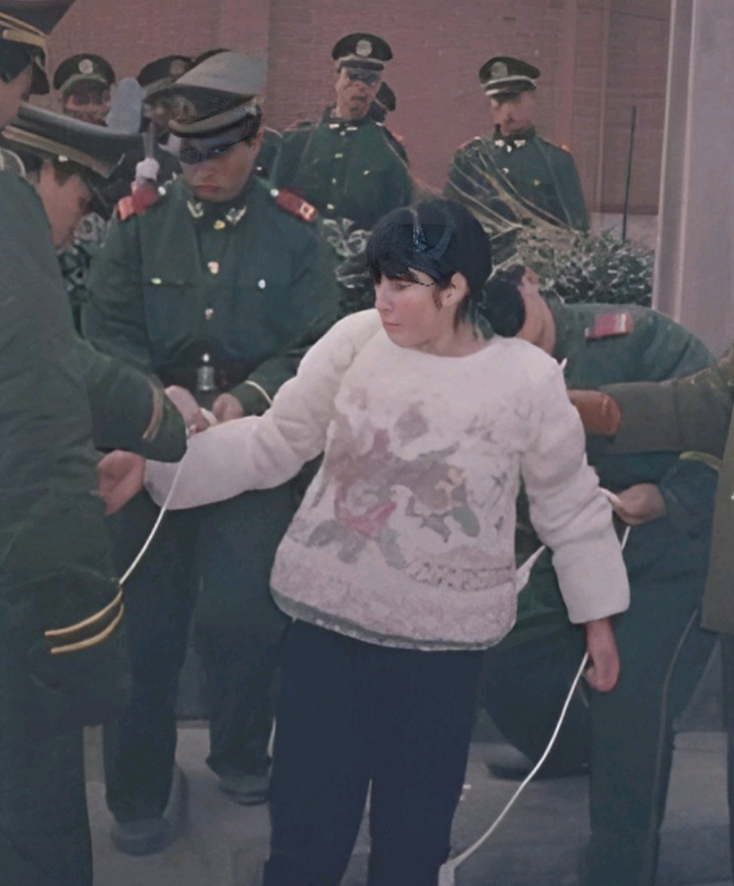 她是一个让人心疼的女死刑犯,在画面中,她正配合法警捆绑绳索.