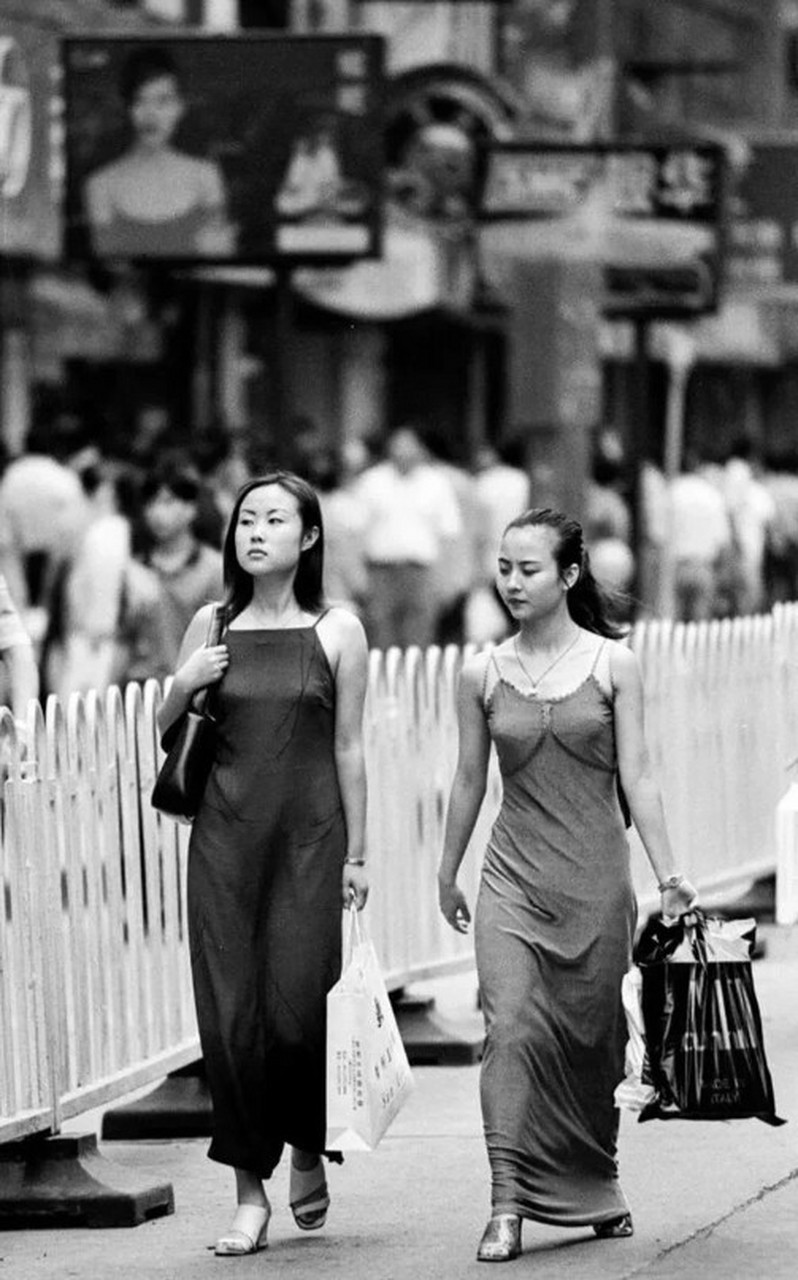 上世纪九十年代,南京路的一位姑娘穿着吊带裙走在街上,而我当时则身穿