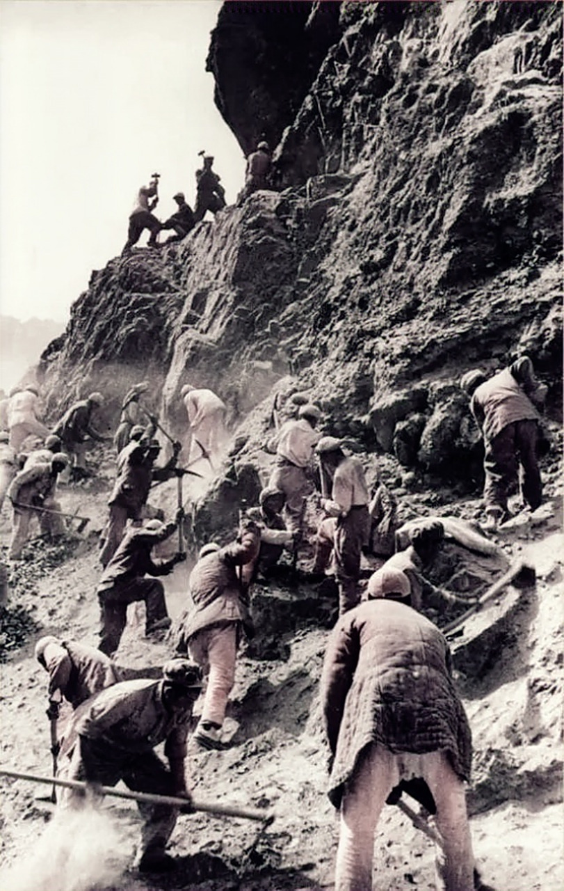 上世纪50年代,人民解放军在悬崖峭壁上修建青藏公路,画面中战士们用
