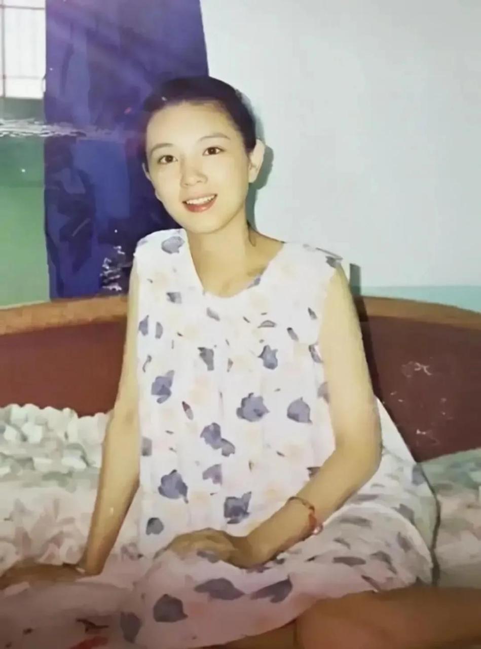 在上世纪90年代,有一张照片的一位年轻姑娘坐在宿舍床上.