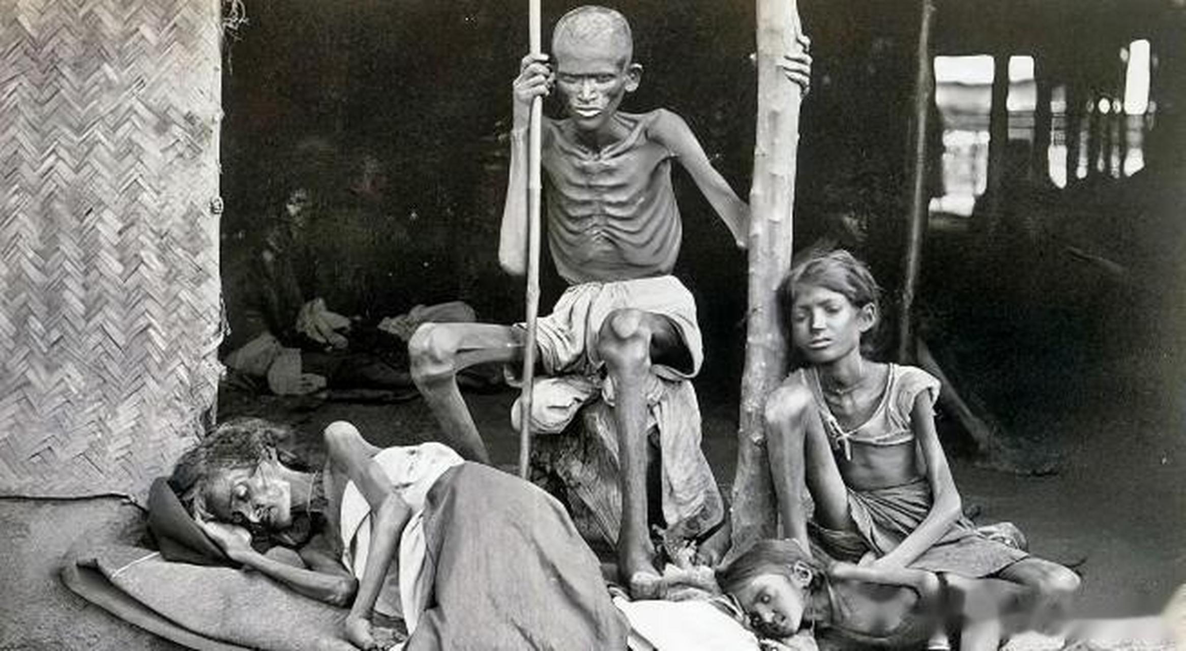 这位饿得皮包骨头仍然拿着棍子的男人保护着家人不被其他饥民吃掉!