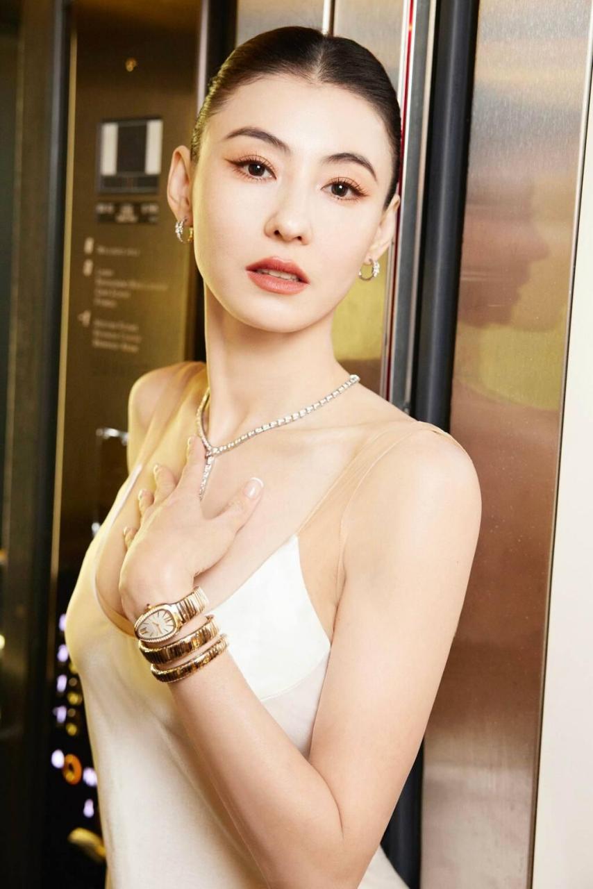 岁张柏芝日前在巴黎出席品牌活动,穿上白色丝质吊带长裙亮相,扎起长发