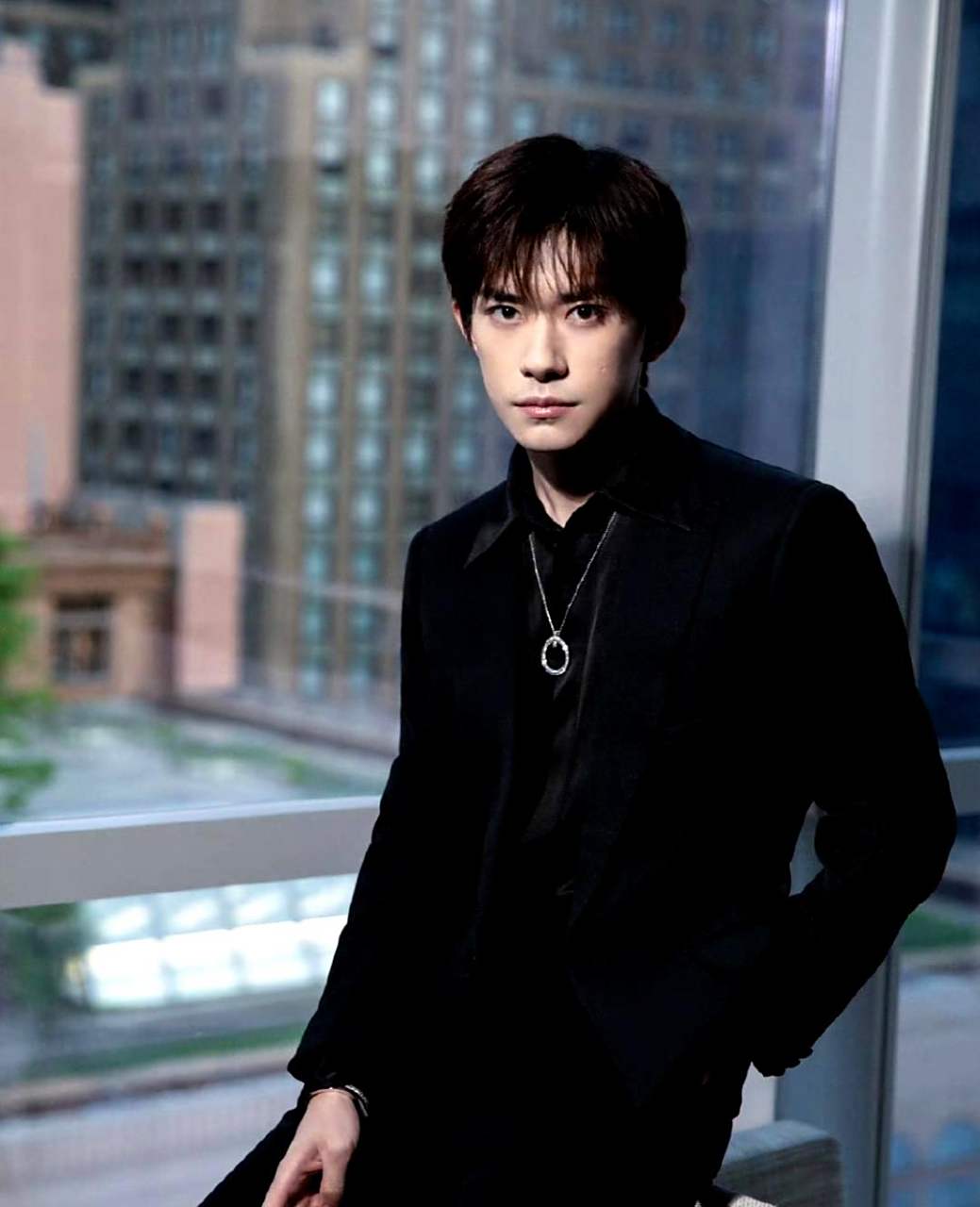 易烊千玺穿着一身黑色西装拍摄大片,脖子上佩戴的钻石项链彰显出他的